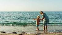 grandmother walks with her grandson on the beach on the sand by the sea