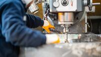 A worker in a factory working on a traditional milling machine