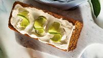 summer sweet loaf cake on a table with flowers and a drink in glasses. with coconut cream and lime. dessert for brunch or mornin