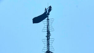 <p>Two people stand on the tip of the antenna of the Empire State Building (Richard Drew/AP)</p>