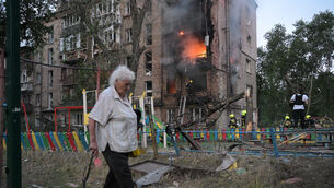 A woman walks past a burning building after a Russian missile attack in Kyiv (AP Photo/Danylo Antoniuk) A woman walks past a burning building after a Russian missile attack in Kyiv (AP Photo/Danylo Antoniuk)