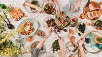Peoples hands with various snacks and blooming mimosa, top view