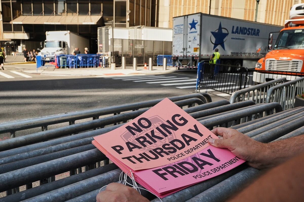 A worker holds "No Parking" signs prior to posting as trucks fill the loading dock outside New York's Madison Square Garden, Wednesday, July 1, 2026. (AP Photo/Richard Drew)