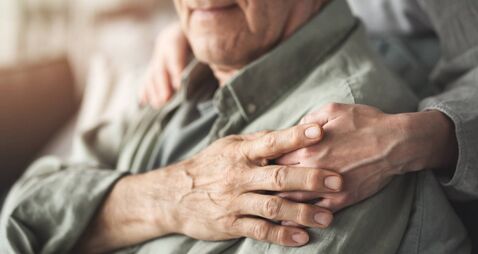 Comforting hand supporting the old man