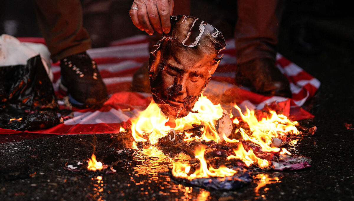 A man burns a photograph of US president Donald Trump during an anti-US and anti-Israeli rally in support of the Iranian government, in Istanbul, Turkey, earlier this year. Picture: Emrah Gurel/AP