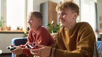 Teenage Brothers Sitting Together Playing Video Games Indoors