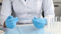 Gynecologist in gloves holds brush and gynecological glass