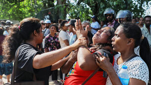 A relative of an inmate breaks down outside a prison where deadly clashes broke out (AP)
