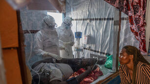 Health workers tend to an Ebola patient at the Rwampara Treatment Centre in Ituri, DR of Congo (Moses Sawasawa/AP)