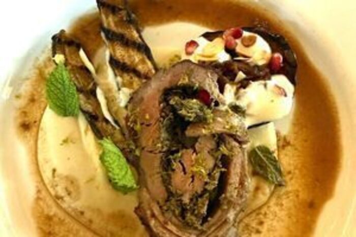 Roast loin of lamb stuffed with walnut and parsley pesto on butter bean mash