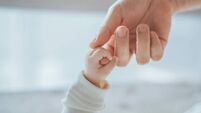 Close-up little hand of child baby holding hand of mother, A newborn holds on to mom's, dad's finger, Love and relationship with
