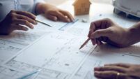 iStock-1281577270.jpg Engineering man showing blueprint detail for people buying house.