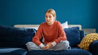 Upset teen girl sitting on sofa at home feeling lonely and frustrated