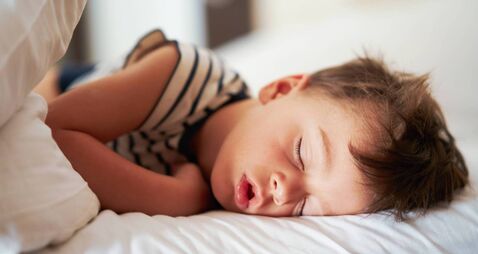 Picture of a tired young boy sleep on holidays
