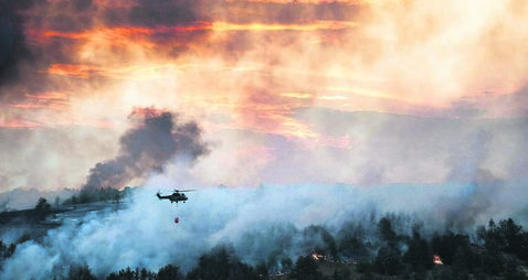 Helicopter dumping water on a wildfire