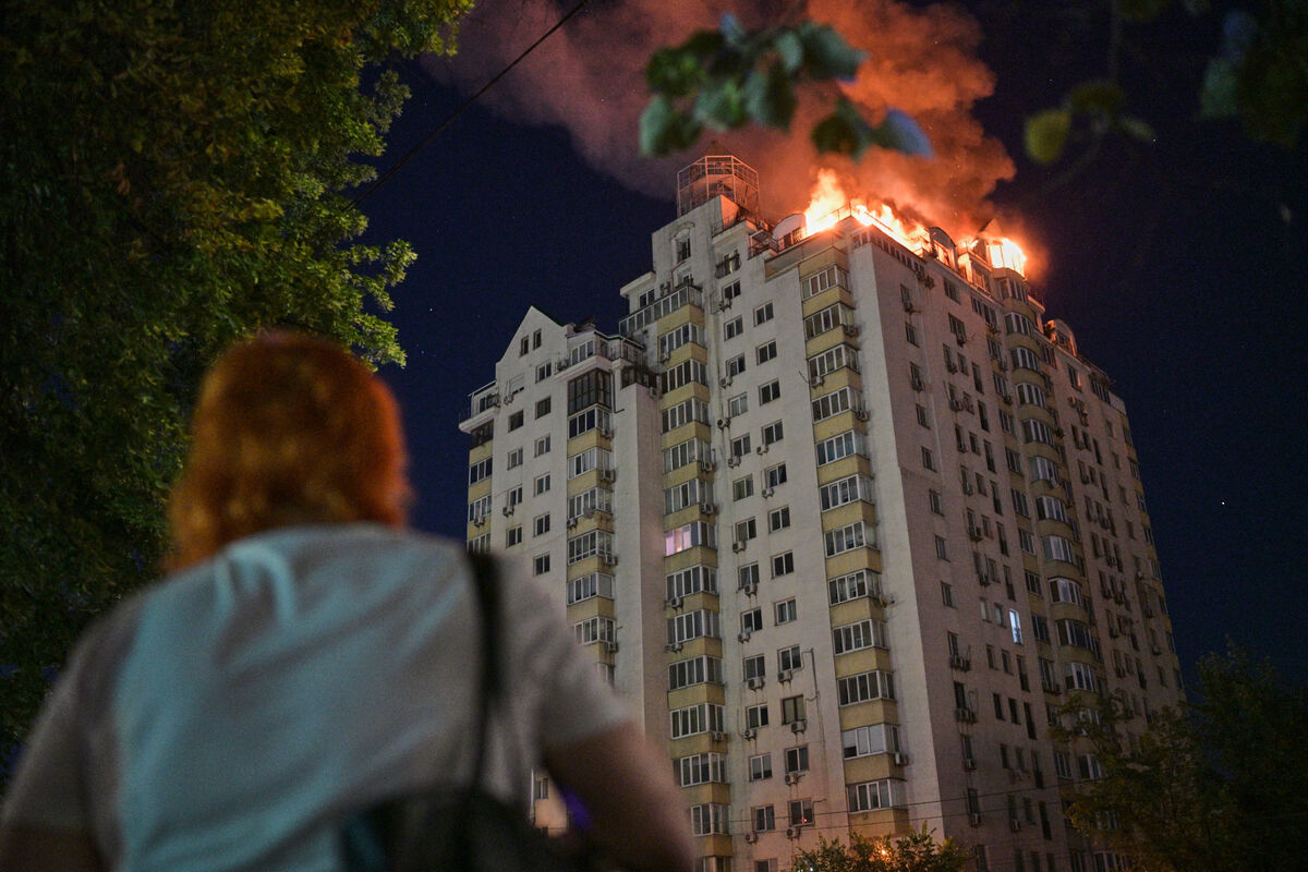 A woman in Kyiv, Ukraine, looks on as an apartment building burns after being hit by a Russian missile on July 2. Picture: Danylo Antoniuk/AP A woman in Kyiv, Ukraine, looks on as an apartment building burns after being hit by a Russian missile on July 2. Picture: Danylo Antoniuk/AP