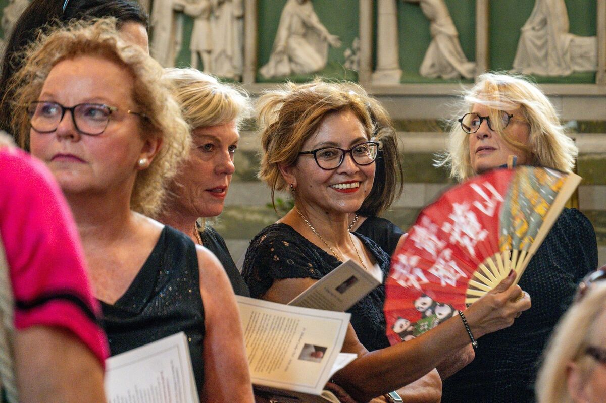  Choir members cool themselves with fans as soaring temperatures add to the intensity of the emotional final Mass at St Augustine’s Church in Cork. Picture: Chani Anderson