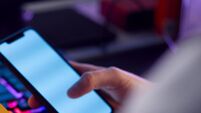 Close Up Of Person With Addiction To Online Gambling Or Shopping Using Credit Card And Mobile Phone