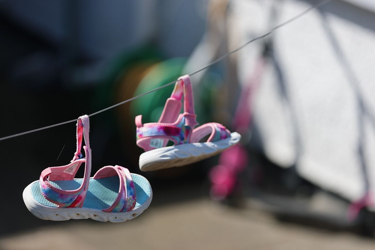 A pair of sandals on a washing line at the scene in the Old Cullybackey Road area of Ballymena, County Antrim, where three people were found dead inside a property on Monday morning. Picture: Liam McBurney/PA Wire A pair of sandals on a washing line at the scene in the Old Cullybackey Road area of Ballymena, County Antrim, where three people were found dead inside a property on Monday morning. Picture: Liam McBurney/PA Wire