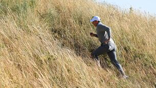 <p>RIGHT DIRECTION: Rory McIlroy picks up the pace though the rough during practice for the Open Championship at Royal Birkdale. Pic: Stuart Kerr/R&amp;A</p>