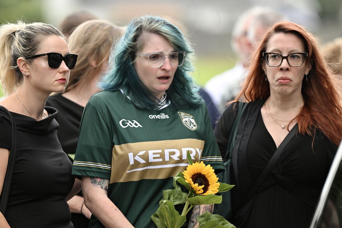A heartbroken Devon, sister of the deceased Jamey Carney, wearing a Kerry football jersey and carrying a single sunflower at St Mary’s Cathedral, Co Kerry. Picture: Larry Cummins A heartbroken Devon, sister of the deceased Jamey Carney, wearing a Kerry football jersey and carrying a single sunflower at St Mary’s Cathedral, Co Kerry. Picture: Larry Cummins