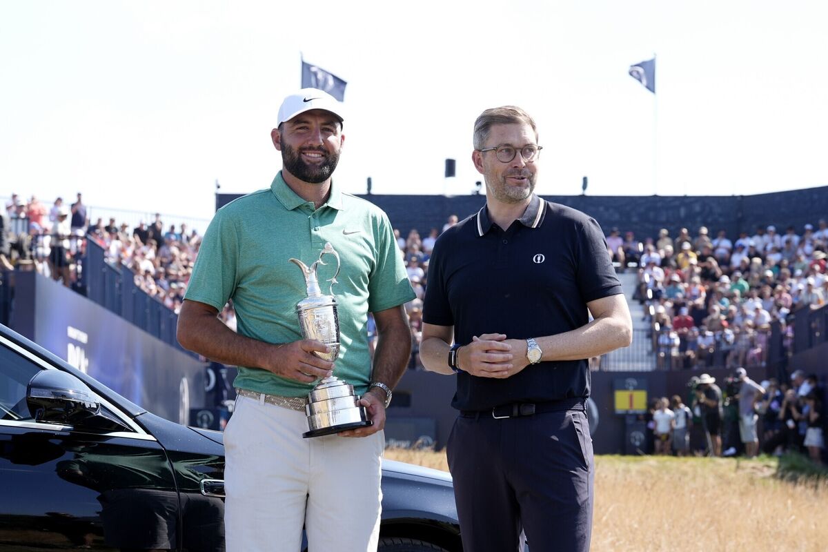 Scottie Scheffler with the Claret Jug as he hands it to R&A chief executive Mark Darbon (right). Pic: Peter Byrne/PA Wire Scottie Scheffler with the Claret Jug as he hands it to R&A chief executive Mark Darbon (right). Pic: Peter Byrne/PA Wire
