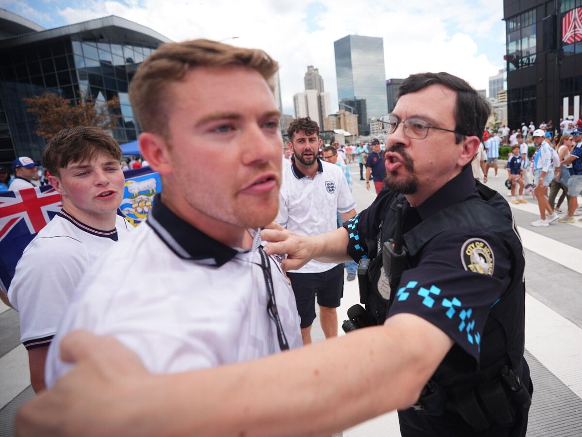 A police officer breaks up an argument between Argentina and England supporters as they leave the Atlanta Stadium. Pic: James Manning/PA Wire A police officer breaks up an argument between Argentina and England supporters as they leave the Atlanta Stadium. Pic: James Manning/PA Wire
