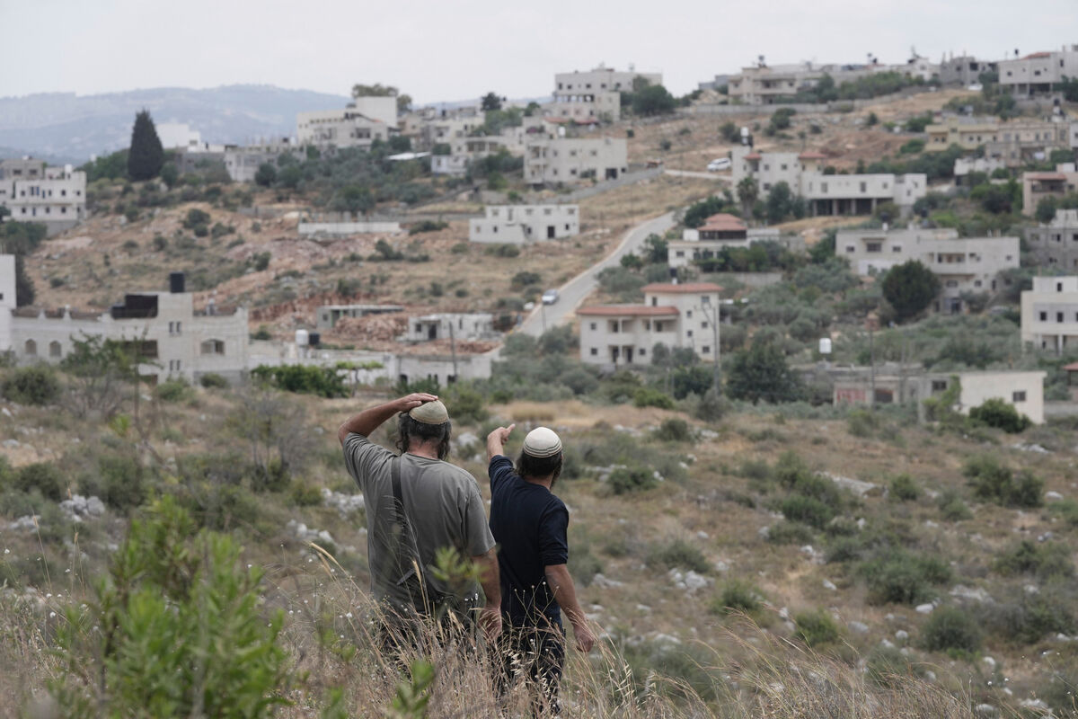 Israeli settlers look towards their neighboring village, outside of the West Bank settlement of Bruchin, Thursday, May 15, 2025. (AP Photo/Maya Alleruzzo) Israeli settlers look towards their neighboring village, outside of the West Bank settlement of Bruchin, Thursday, May 15, 2025. (AP Photo/Maya Alleruzzo)