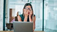 iStock-1189618227.jpg Female entrepreneur with headache sitting at desk