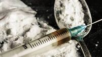 A drug syringe and a spoon with cooked heroin