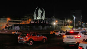 Vehicles drive past a monument depicting the clenched fist of the late Iranian supreme leader Ayatollah Ali Khamenei in Islamic Revolution Square, Tehran (Vahid Salemi/AP) Vehicles drive past a monument depicting the clenched fist of the late Iranian supreme leader Ayatollah Ali Khamenei in Islamic Revolution Square, Tehran (Vahid Salemi/AP)