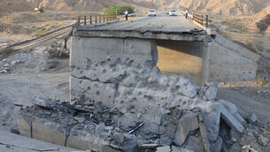 <p>People stand on a bridge destroyed after a strike in Hormozgan province on Saturday (Amirhosein Khorgooi/Iranian Students’ News Agency via AP)</p> <p>People stand on a bridge destroyed after a strike in Hormozgan province on Saturday (Amirhosein Khorgooi/Iranian Students’ News Agency via AP)</p>