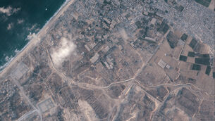 <p>A section of the earthen barrier, cutting horizontally across the middle of the image, being built by the Israeli military. On one side are two military bases, and on the other the Palestinian tent city of Muwasi (Planet Labs PBC/AP)</p> <p>A section of the earthen barrier, cutting horizontally across the middle of the image, being built by the Israeli military. On one side are two military bases, and on the other the Palestinian tent city of Muwasi (Planet Labs PBC/AP)</p>