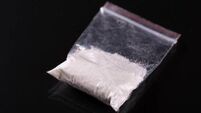 Cocaine in plastic packet on black background