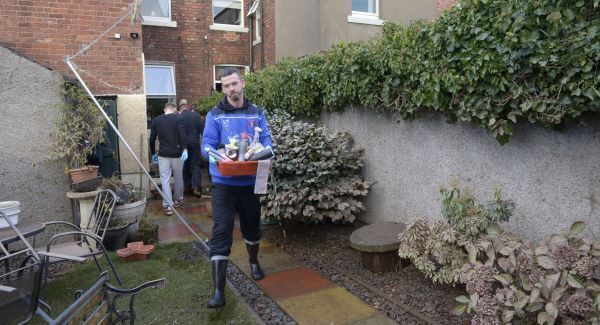 Michael Raynes helps to clear items from a flood-damaged home in Carlisle. Photo: Ben Birchall/PA