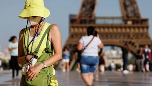 <p>A tourist wearing a hat and a face mask walks during a heatwave at the Trocadero square in front of the Eiffel Tower, in Paris. Picture: Ludovic MARIN / AFP</p> <p>A tourist wearing a hat and a face mask walks during a heatwave at the Trocadero square in front of the Eiffel Tower, in Paris. Picture: Ludovic MARIN / AFP</p>