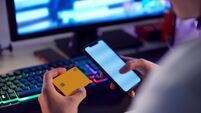 Close Up Of Person With Addiction To Online Gambling Or Shopping Using Credit Card And Mobile Phone