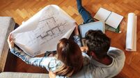 Young couple examining blueprints of they new home.