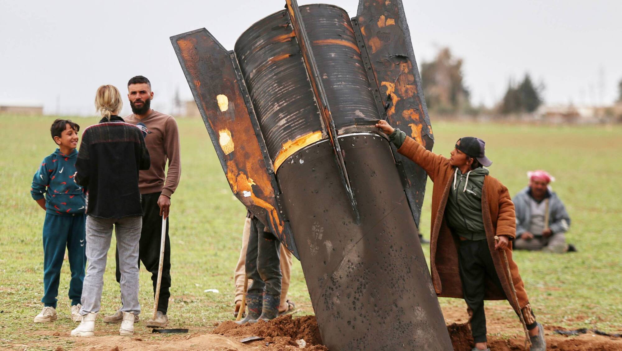 A young boy touches an unexploded Iranian projectile that landed in an open field in the outskirts of Qamishli, Syria, this March. File picture Baderkhan Ahmad/AP