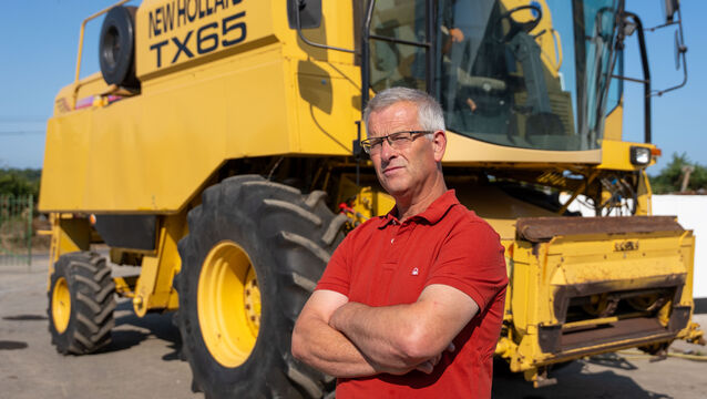 <p>Nick Dunican, who survived after the combine harvester he was operating overturned with him inside, in front of the machine he was driving at the time. Picture: Noel Sweeney</p>