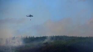 <p>Members of the Irish Air Corps provide aerial support in tackling a major wildfire as it continues to burn at Slievenamon in Co Tipperary. Firefighters are spending a fourth day tackling a significant and large mountain wildfire in Co Tipperary, which has spread to an adjoining forest. Picture date: Thursday July 23, 2026. PA Photo. Photo credit should read: Brian Lawless/PA Wire</p>