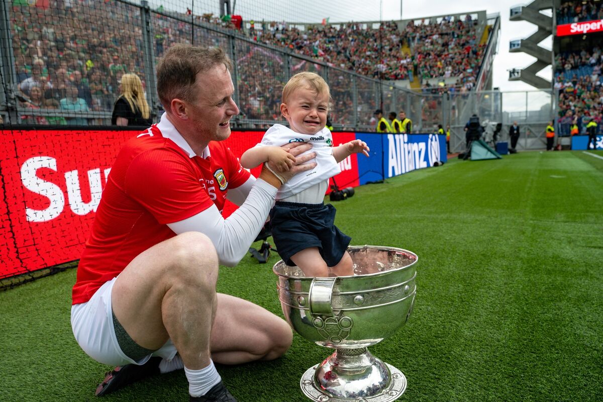 Mayo goalkeeper Robbie Hennelly puts his son in the Sam Maguire Cup. Pic: Chani Anderson Mayo goalkeeper Robbie Hennelly puts his son in the Sam Maguire Cup. Pic: Chani Anderson