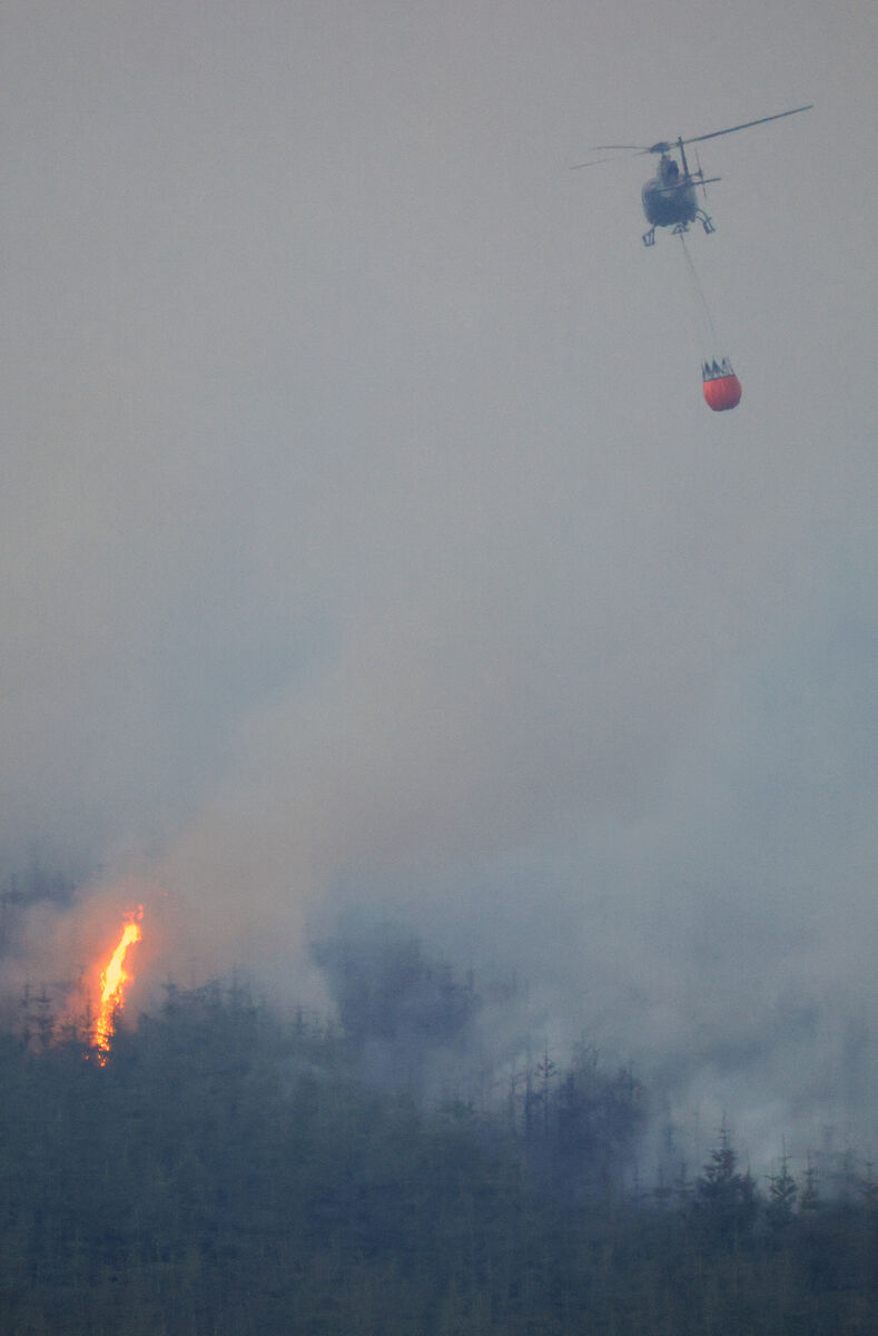 A helicopter dropping water on the fire that spread to an adjacent Coillte forest after changes in wind direction. The wildfire that is burning across Slievenamon in Co Tipperary split into three separate fires. Picture: Eamonn Farrell /  RollingNews.ie