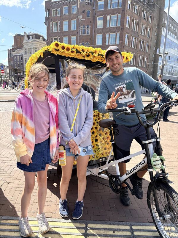Vickie's daughters enjoy a sunflower-studded rickshaw tour of Amsterdam with Bobby from I am Bike.