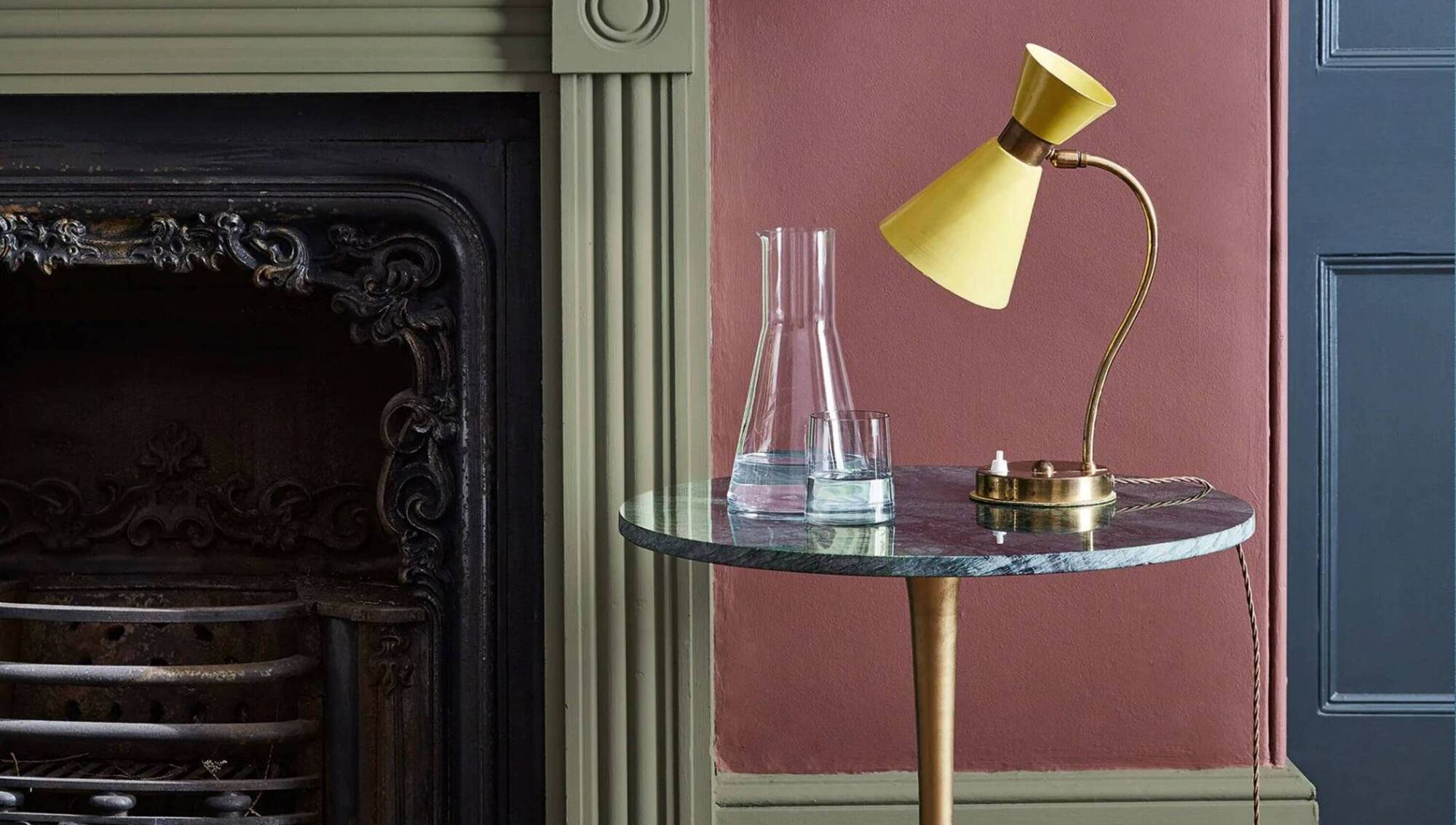 A bold, modern triadic colour scheme hangs on Little Greene's colour for 2026, Adventurer, a warm aubergine. Hicks Blue (door) and Acorn Mid (fireplace). The sizzling yellow vintage lamp holds its own, €38 per litre, suppliers include Hickeys of Maylor Street, Cork.