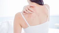 woman scratching shoulder and neck