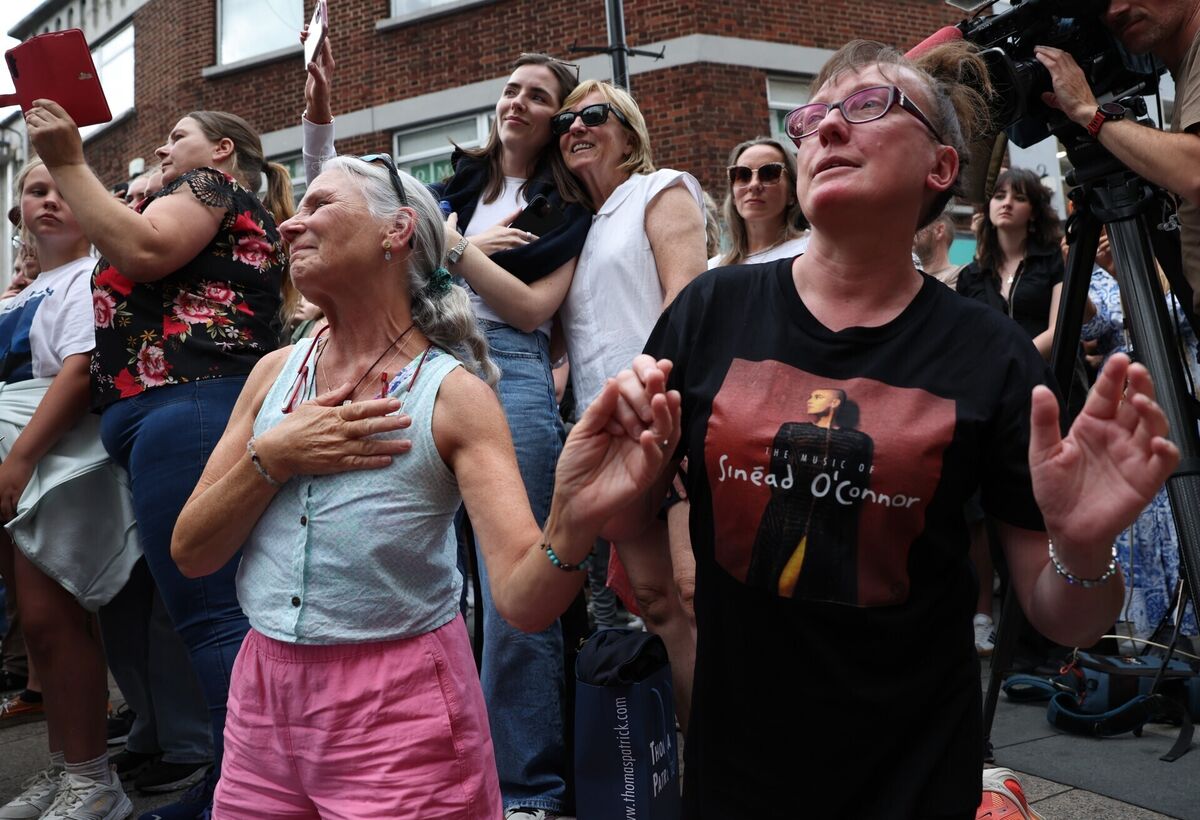 Joyce Richardson and Martina Hands hold hands as they listen to musicians play in memory of Glen Hansard on King Street in Dublin. Picture: Damien Eagers/PA Joyce Richardson and Martina Hands hold hands as they listen to musicians play in memory of Glen Hansard on King Street in Dublin. Picture: Damien Eagers/PA