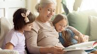Grandmother reading a book to two granddaughters