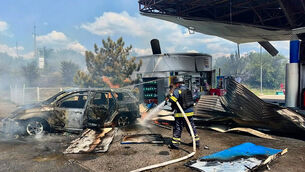 Firefighters put out a fire at a gas station following a Russian drone attack in Dnipropetrovsk region (Ukrainian Emergency Service via AP)