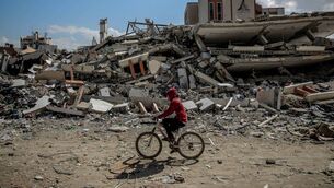 <p>A man rides his bicycle past the al-Aqsa University, levelled by Israeli bombardment in Gaza City on February 15, 2024. Picture: AFP via Getty Images</p> <p>A man rides his bicycle past the al-Aqsa University, levelled by Israeli bombardment in Gaza City on February 15, 2024. Picture: AFP via Getty Images</p>